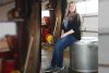 Amanda Pantrey sits atop the South Frontenac Time Capsule at its current home in the Keeley Road Garage. It will likely be buried in the spring after the ground unfreezes. Photo/Craig Bakay