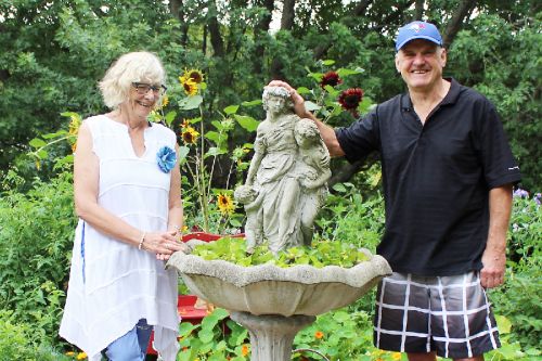 Linda and Brian Hetherington in their ‘potager’ garden with their 15-year-old border collie Terra. Brian’s father made the birdbath that serves as the hub of the garden wheel. Photo/Craig Bakay
