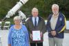 Robert Dick (far right) presents Councilor Betty Hunter and Mayor Bud Clayton with the North Frontenac Dark Skies Preserve citation