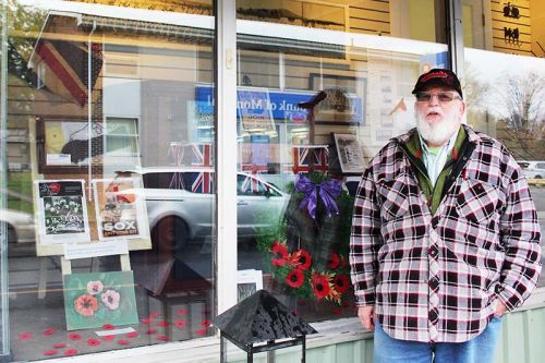 Doug Lovegrove stands in front of the Remembrance display in the window of Nicole’s Gifts in Verona. “Nicky’s been very supportive,” he said. Photo/Craig Bakay