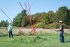 Stefan Duerst and Tony Orr take two poles from the Oh! Canada Teepee off into the bush to complete the installation.