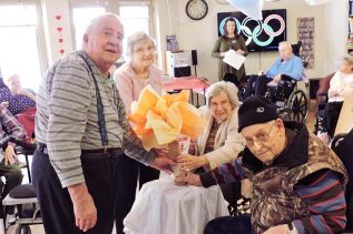 Holding the Olympic torch, left to right, Gordon Spicer, Marion McWilliams, Lily Hundey, Edmund Trudeau.