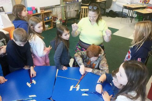 GREC students learning finger weaving
