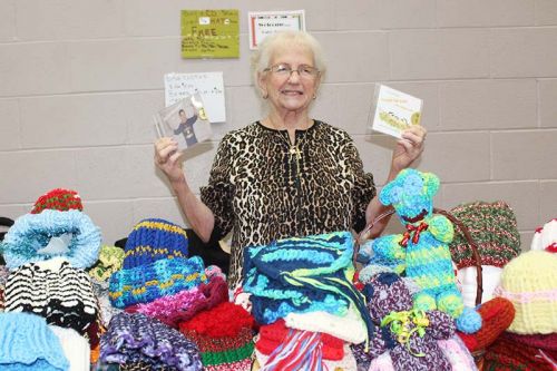 Rev. Patsy Schmidt shows two of her CDs she was selling at the annual Christmas in the Village craft fair put on by the Harrowsmith Free Methodist Church Saturday. Schmidt is about to release her 10th CD of gospel music and has penned more than 150 songs. She was also selling her knitted hats, scarves and other items. She said knitting is good for her hands. “The doctor told me to squeeze balls but that’s a waste of time,” she said. Photo/Craig Bakay