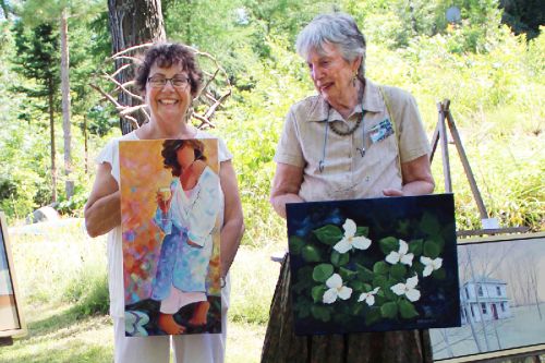 Judith Versavel (l) and Aileen Merriam show off a couple of their pieces amidst the works of co-exhibitors John DuChene (paintings) and Jim Hanley (sculptures). Photo/Craig Bakay