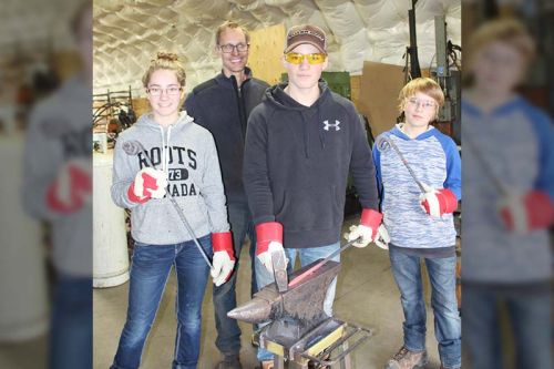 Class was in session last Saturday as master sculptor Stefan Duerst has being holding classes for kids. Here the Perry kids (Kaitlyn, Grant and Mason) are going through the various steps to create pokers and hooks. Photo/Craig Bakay