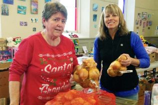 Linda Bates and Sue Clinton adding fresh vegetables to the South Frontenac Christmas baskets.
