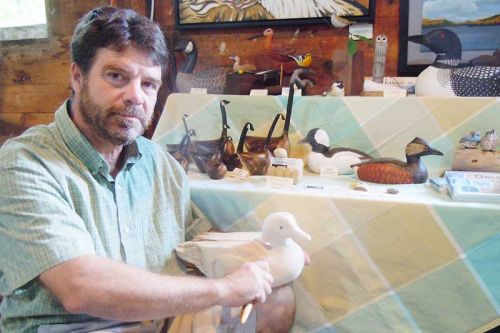 Award-winning wood carver Ted Stewart of Newboro with his wild fowl carvings at the 2nd annual Art in the Saw Mill show in Verona