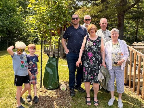 Members of the extended Conboy family at a commemorative tree that was planted at the Child Centre in honour of Keith, who served on the RFCS Board for over 4 decades