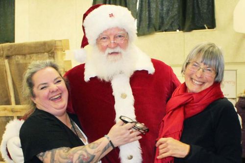 Organizers Alison Williams and Laura Simmons get a hug from Santa at the Holiday Market last Saturday in Prince Charles Public School. Photo/Craig Bakay