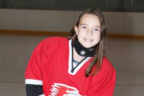 Leah with a customized device that allows her to hold a hockey stick.