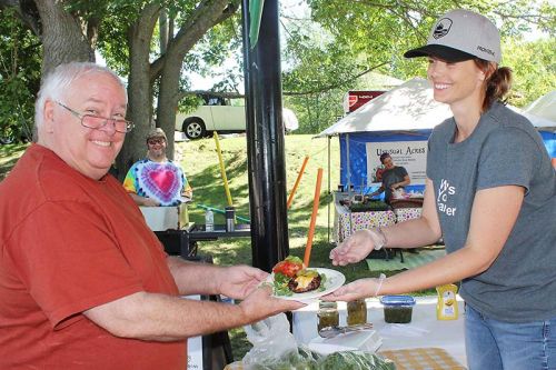Chuck Belcher receives his ‘locavore’ from Kate Howes. Photo/Craig Bakay