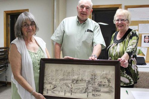Central Frontenac Railway Heritage Society directors Sally Angle, Wayne Moase and Barb Neill show the recently acquired depiction of a train wreck on the K & P April 22, 1879. The Society is currently “scoping out” a permanent home for the artifact. Photo/Craig Bakay