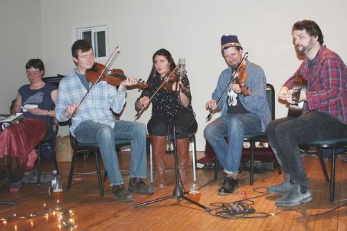 Caller Sarah Vannorstrand goes over her notes while the band — Doug Dorward, Emilia Bartellas, Teilhard Frost and Tom Power warms up at the Maberly Quarterly last Saturday night in Maberly. Photo/Craig Bakay