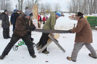 Chad and Glen Matson show how it used to be done in the days before chainsaws as Chucky Millard keeps their log steady at the Matson Family Fun Day at the Farm Sunday during the 14th annual Frontenac Heritage Festival. Photo/Craig Bakay