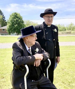 Pastor Carl Bull (top right) dressed as a circuit rider, and Glen Snook, wearing a hat in the style in fashion when he joined the congregation, over 80 years ago.