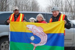 KI band members unfurl their flag in Sharbot Lake and Kaladar