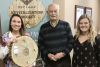 RKY staffers Katie Peruniak and Emma Langlois presenting a plaque to Brit Smith