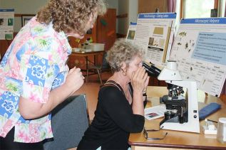 Lucia Chown has a look at some microscopic critters as Loughborough Lake Association President Barbara Canton awaits her turn.