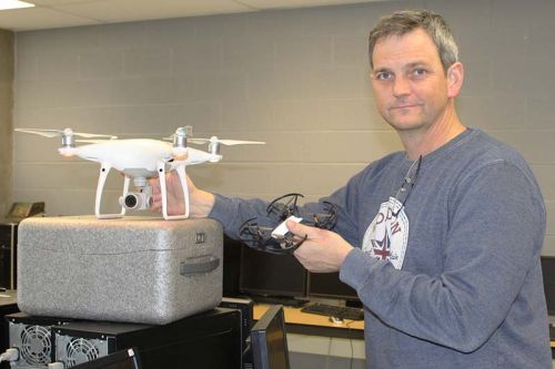 Teacher Wade Leonard shows the two kinds of drones they use in the GREC program — the larger white one is used for most ‘missions’ and the smaller black one is used primarily for flight instruction but they do see limited service in the field. The trainer drones were a community contribution. Photo/Craig Bakay