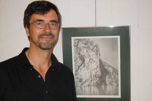artist Michael Neelin beside one of his drawings at the opening of his show “Fenceline and Shoreline” at the MERA Schoolhouse in McDonalds Corners