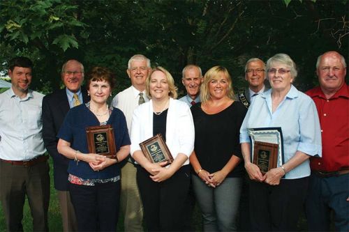 South Frontenac’s 2017 Volunteers of the Year Judy Conway, Rosanne Gandl Black, Lynn Newton and Ruth Shannon along with some of the boys on Council in the backgraoud Photo/Craig Bakay