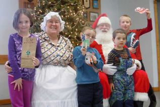Maddy, Dalton, Jeremy and Noah pose with Santa and Mrs. Claus and show off the holiday creations they made at the VCA's 2nd annual Christmas in the Village event